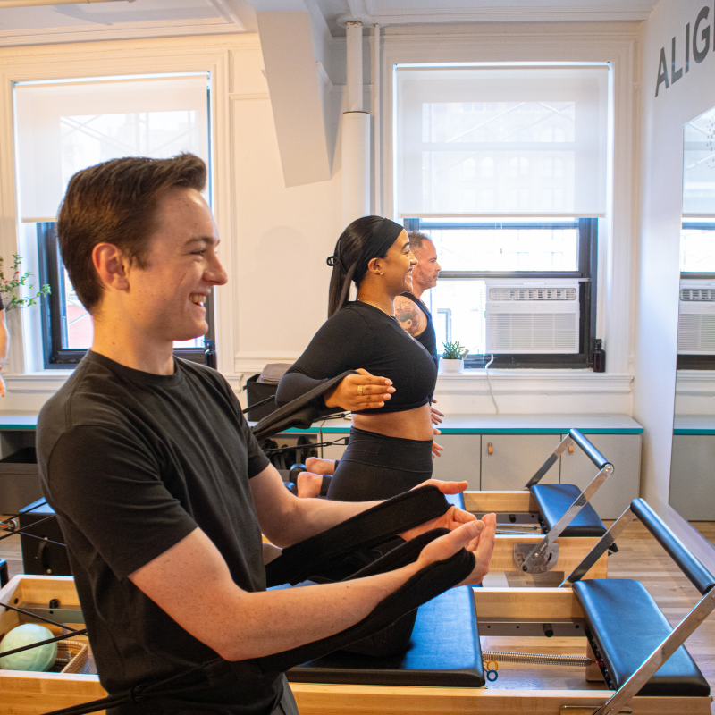 Pilates clients working on reformers during a class at Enhancewell